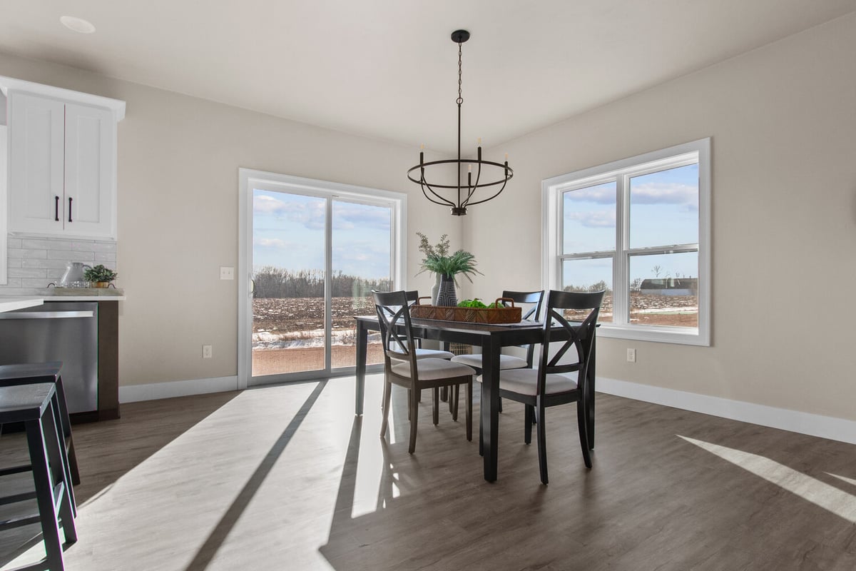 Dining area with black chandelier and large windows in custom home by Midwest Design Homes in Kaukauna, WI