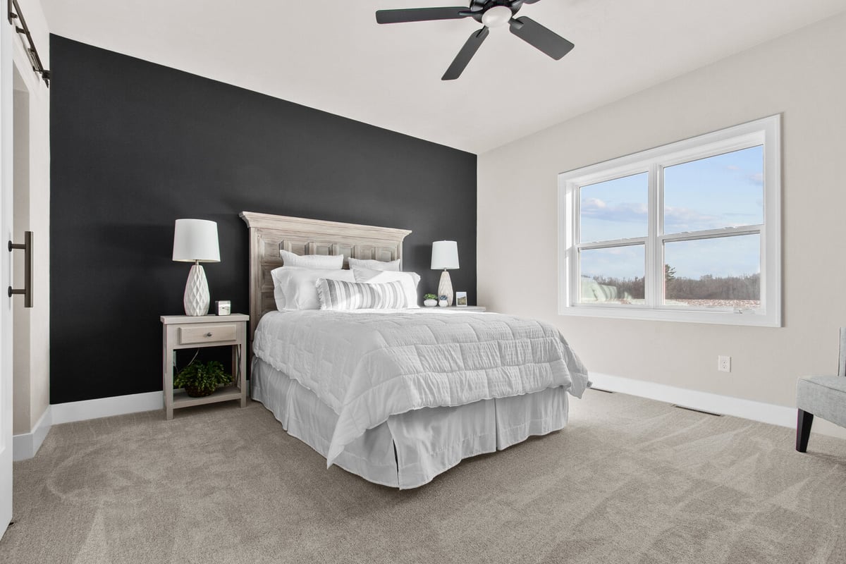 Modern custom home bedroom with black accent wall by Midwest Design Homes in Ellington, WI