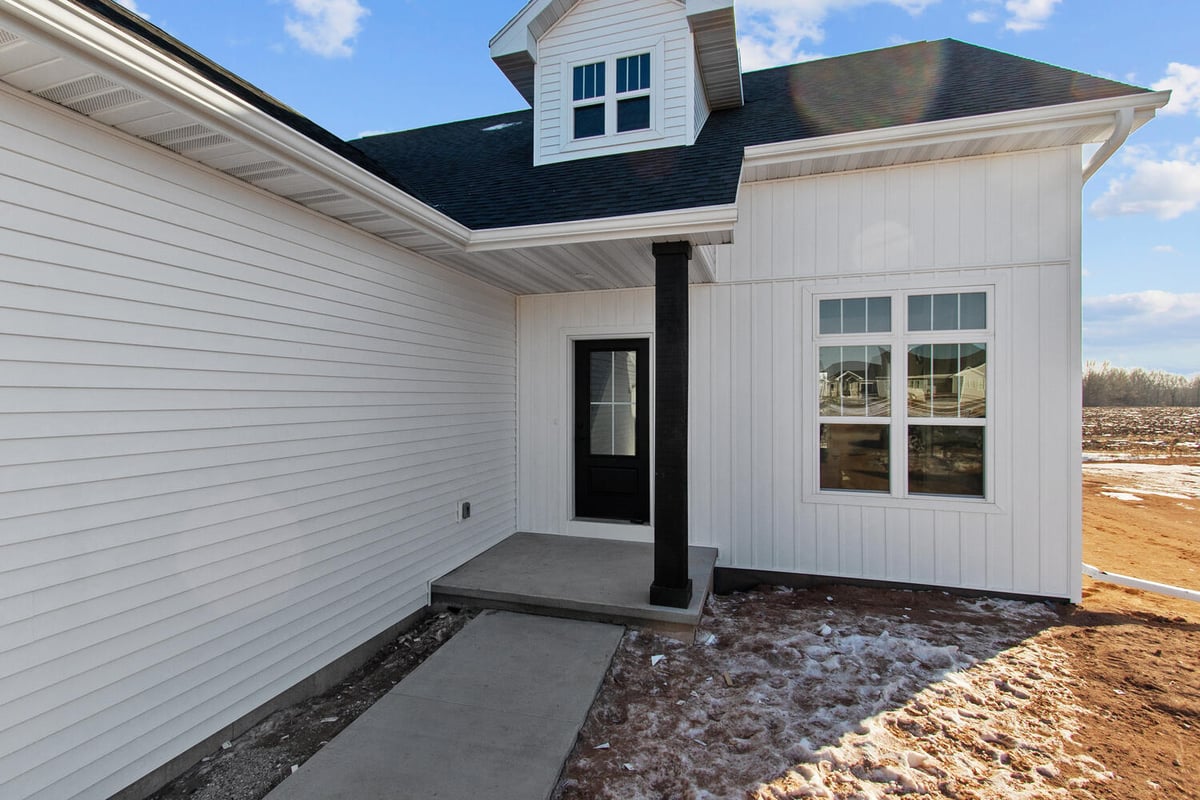 Small concrete porch and front door of new Midwest Design Homes custom build in Ledgeview, WI