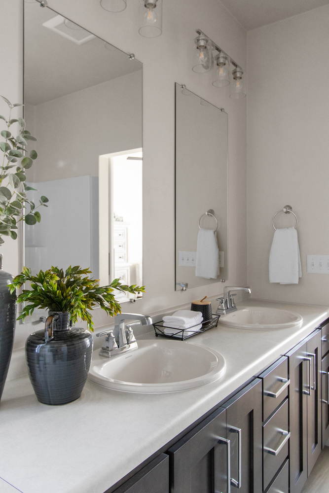 White bathroom sinks with dark cabinets in a custom build by Midwest Design Homes in Greenville, WI