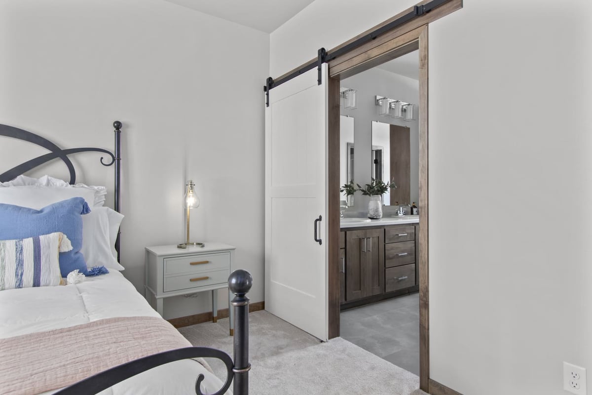 Bedroom with a view into ensuite bath featuring wood cabinetry in a Fox Cities home