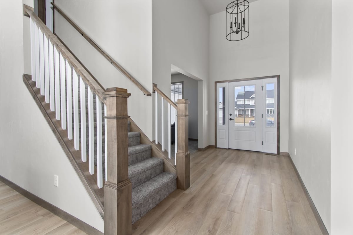 Bright entryway in a Fox Cities home featuring wood flooring and a carpeted staircase