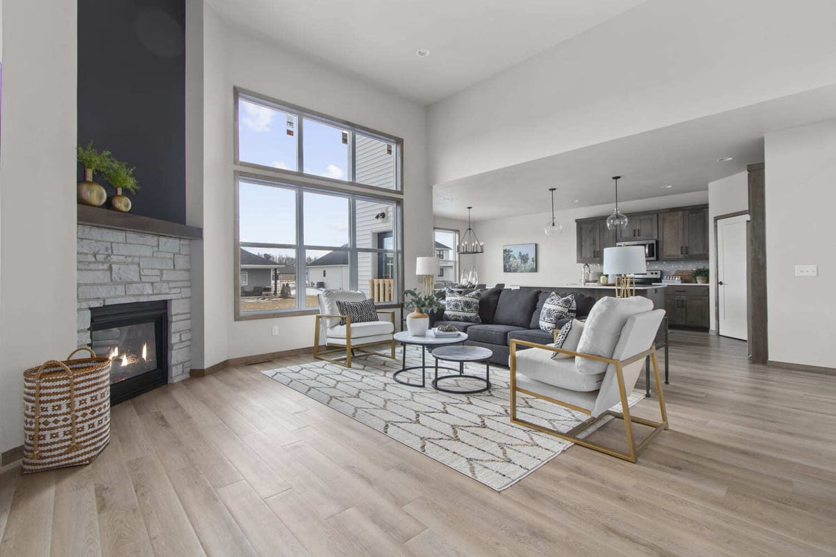 Bright open living room with fireplace connected to kitchen, modern decor and large windows in the Fox Cities