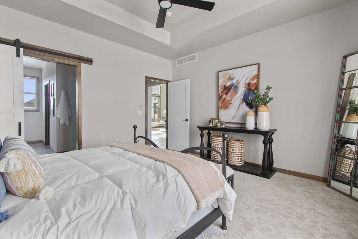 Cozy Fox Cities bedroom with tray ceiling, black bed frame, and neutral-toned decor