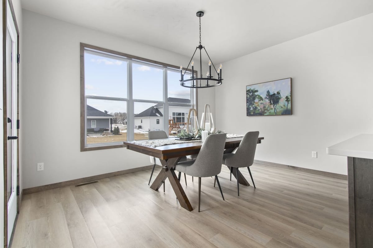 Dining area in a Fox Cities home with large windows, modern light fixture, and wood flooring