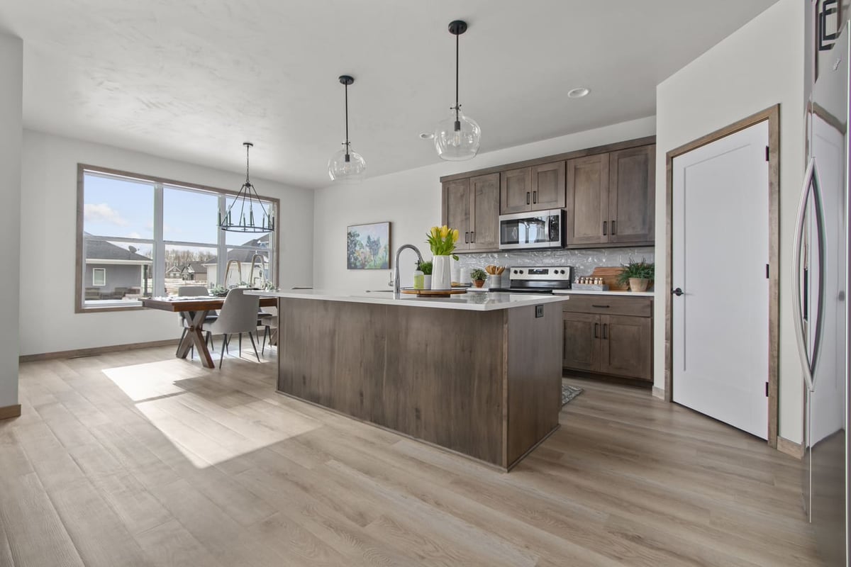 Fox Cities kitchen and dining area with wood cabinets, large island, and natural light from expansive windows