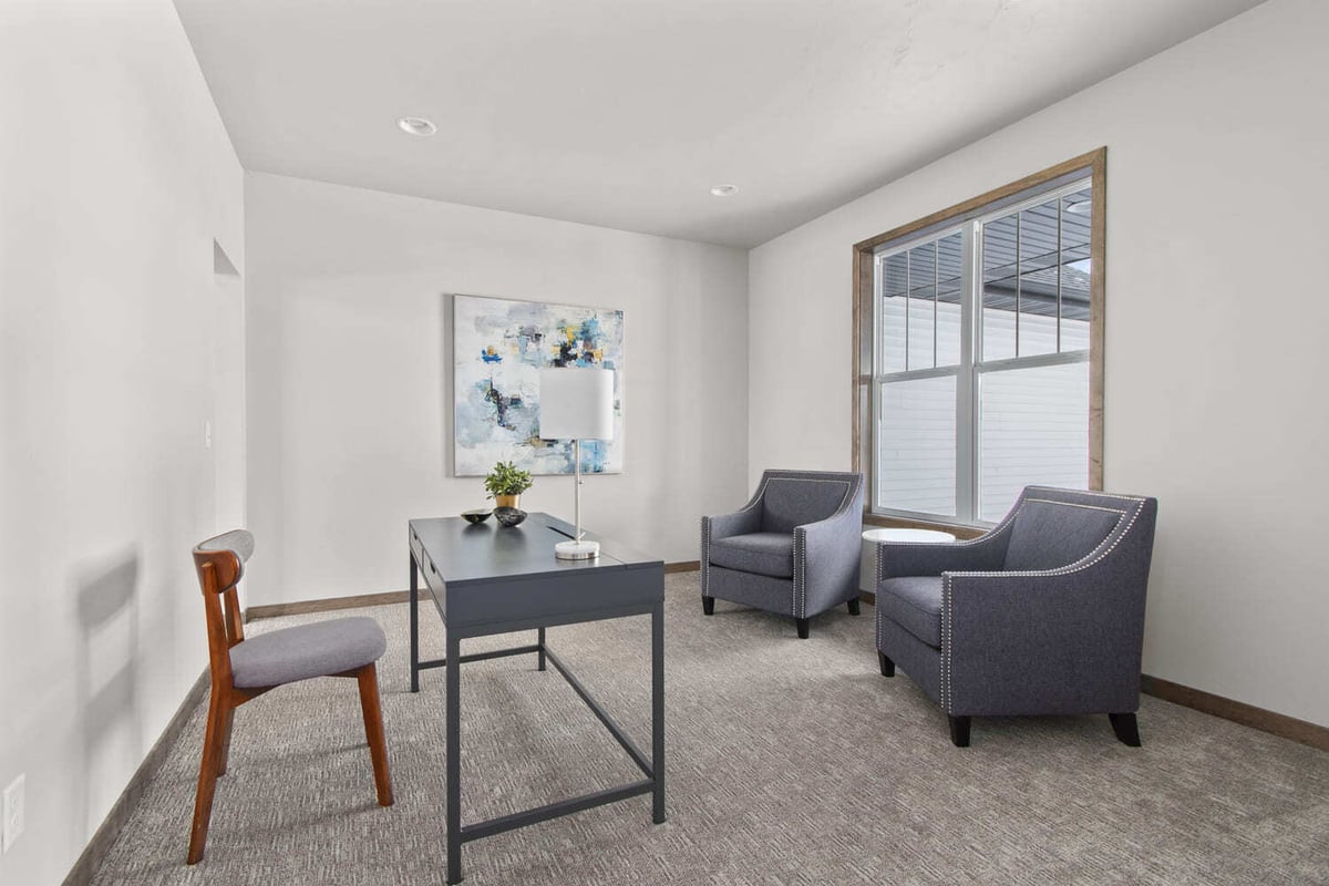 Minimalist Fox Cities home office with two armchairs, writing desk, and large window for natural light