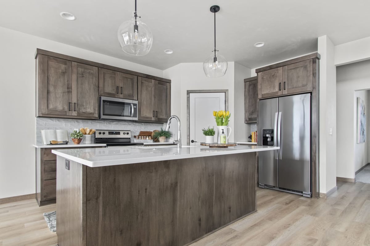 Modern kitchen in the Fox Cities with white countertops, wood cabinetry, and stainless steel appliances