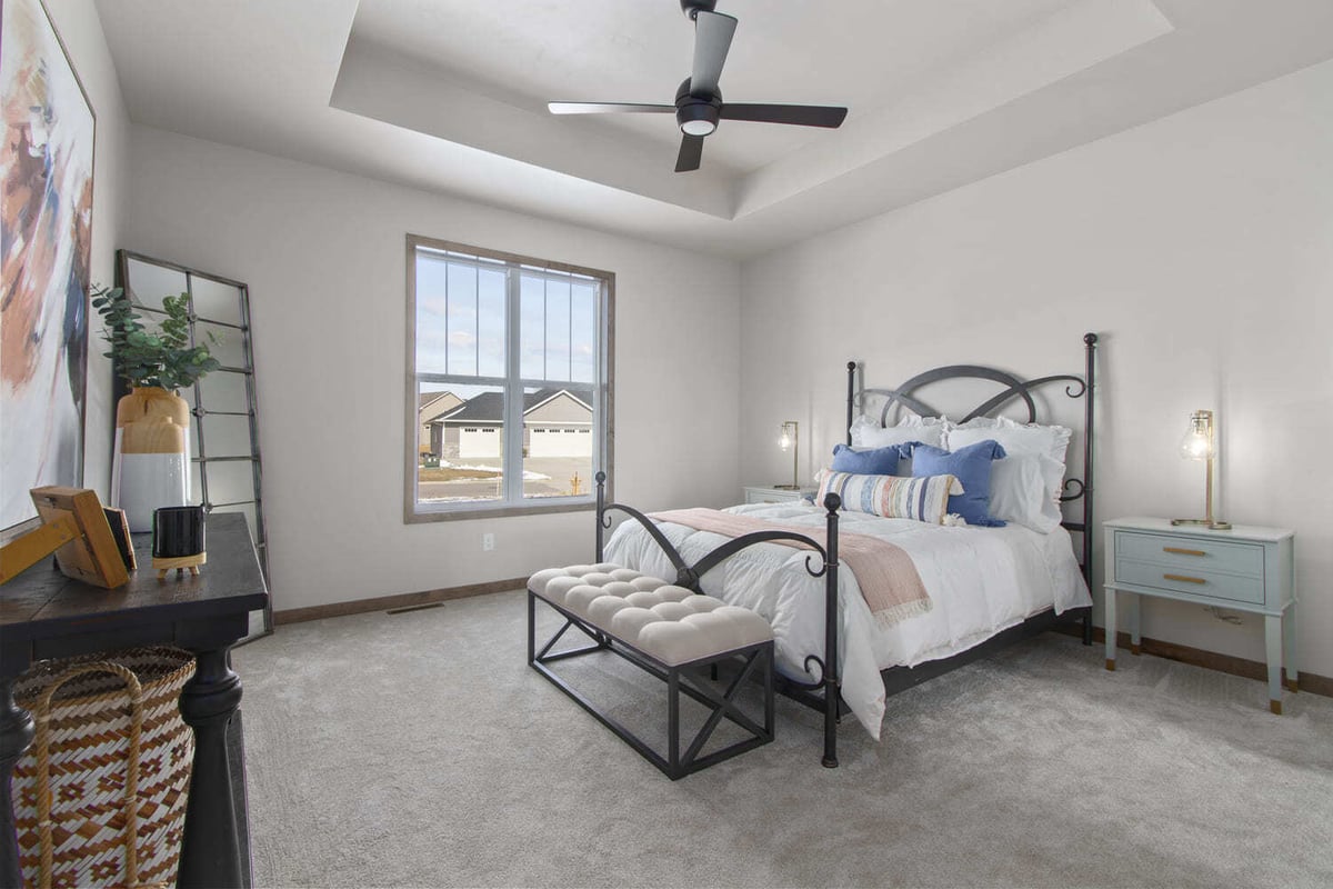 Spacious bedroom with tray ceiling, large window, and cozy decor, located in the Fox Cities