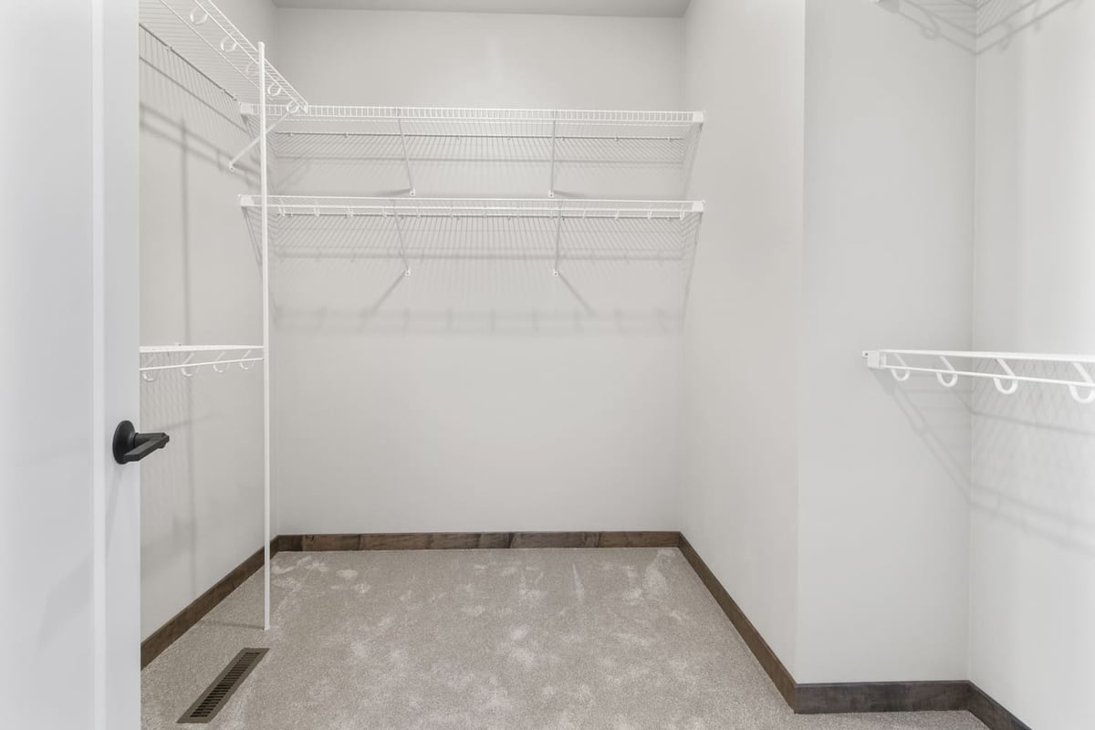 Walk-in closet in the Fox Cities with white wire shelving and neutral carpet flooring