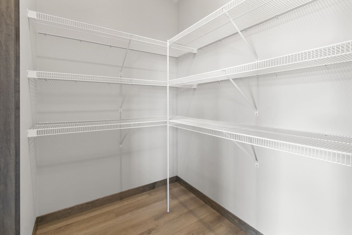 Walk-in closet with white wire shelving in a modern Fox Cities home