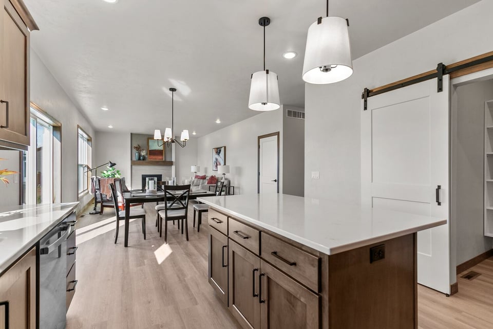 Custom kitchen island overlooking dining and living space by Midwest Design Homes in Ledgeview, WI