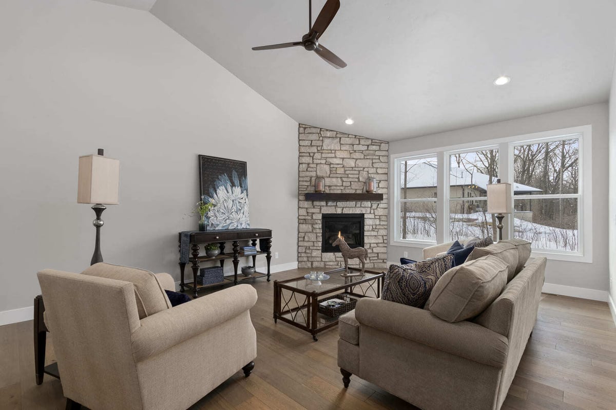 Cozy living room with stone fireplace, vaulted ceiling, and seating area in a Fox Cities home