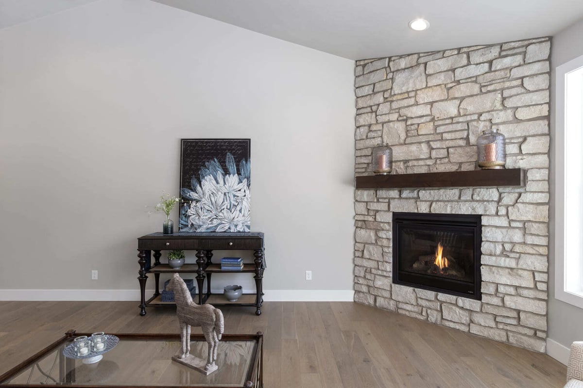 Fox Cities living room with stone fireplace, decorative console table, neutral furniture, and wide plank floors