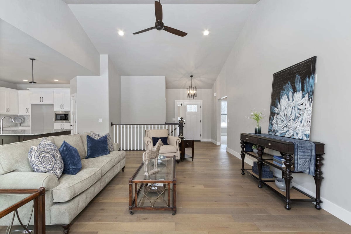 Fox Cities open living area showing kitchen island, dining space, hardwood floors, and modern pendant lighting