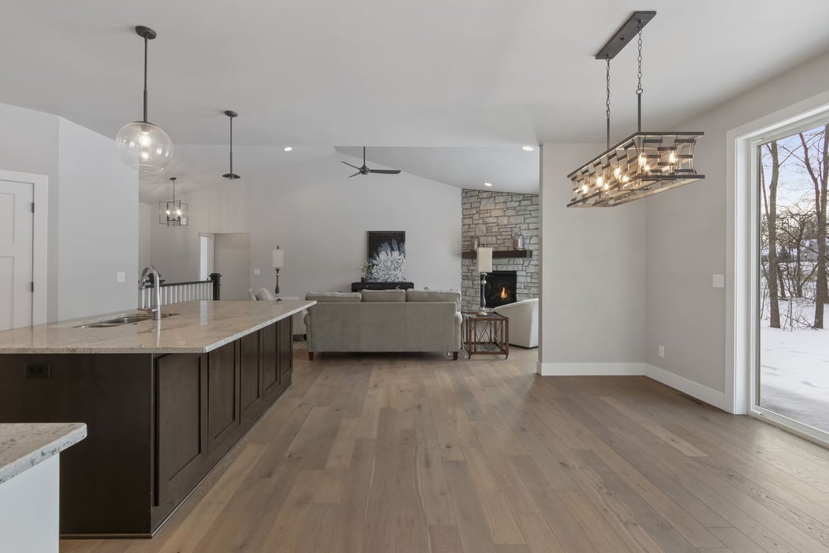 Wide view of kitchen island flowing into living room and dining space in a Fox Cities home