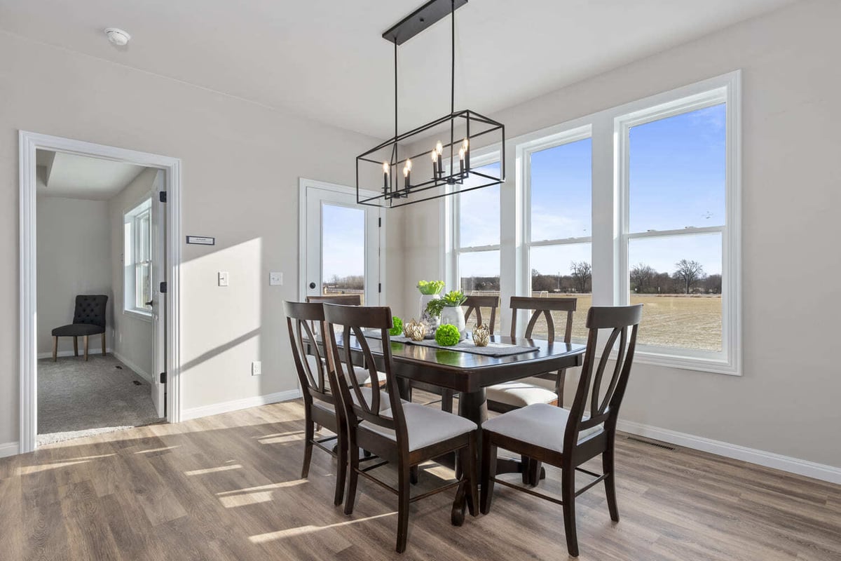 Dining area with wood table, modern chandelier, and large windows overlooking fields in the Fox Cities