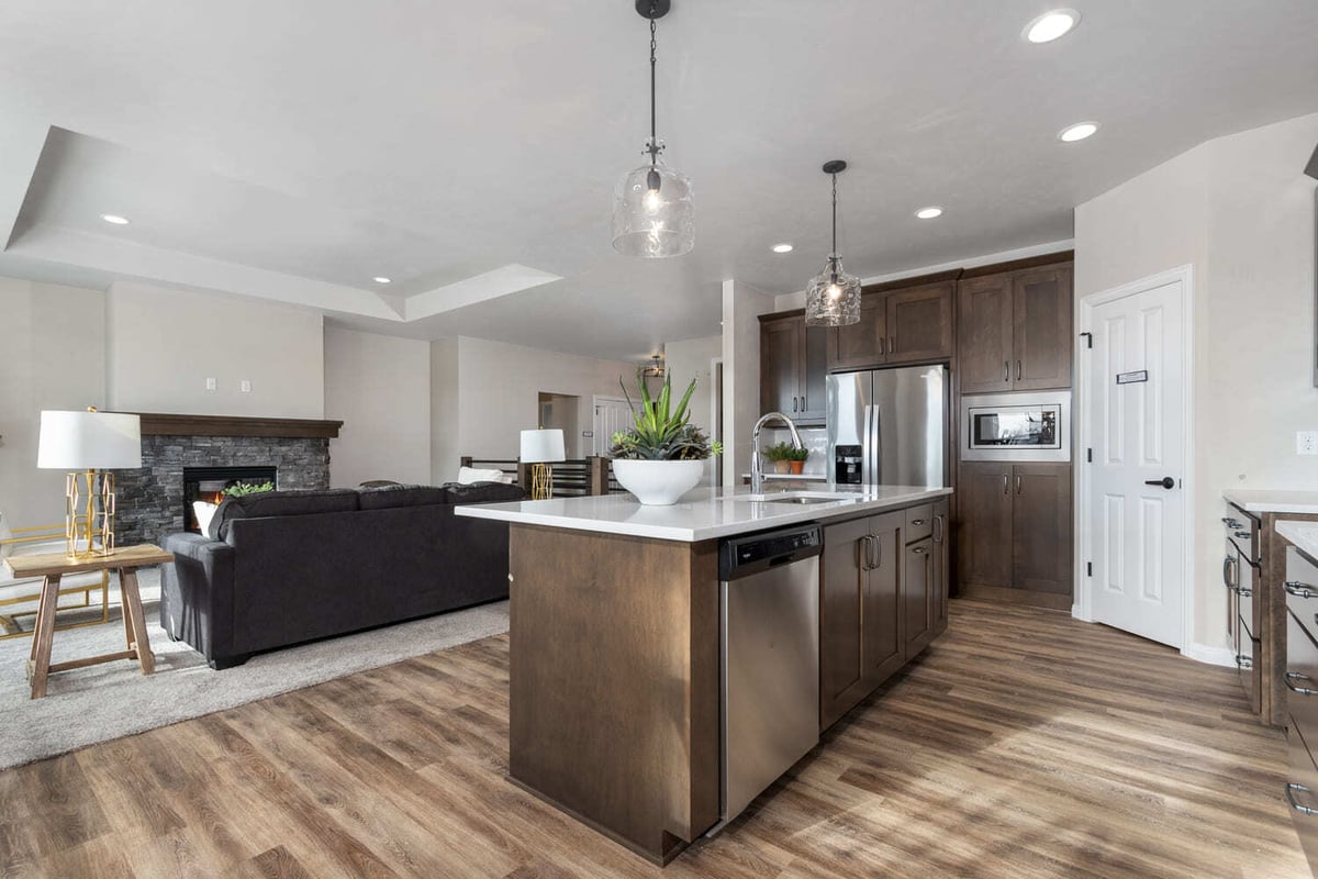 Kitchen island with seating, stainless appliances, and open living space in a Fox Cities home