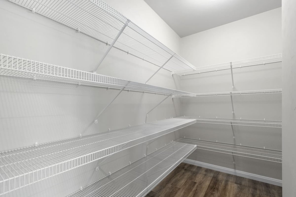 Large walk-in pantry with wood-look flooring and white wire shelving in a Fox Cities home