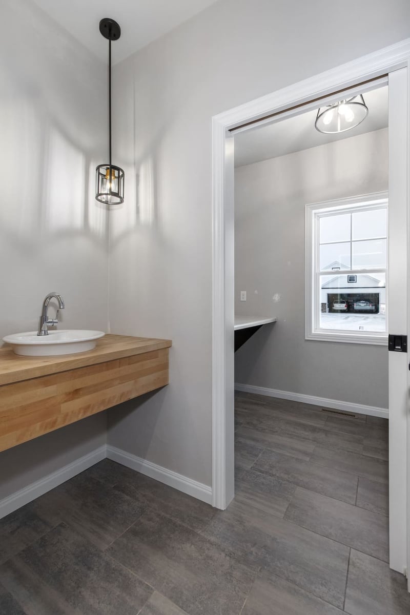 Powder room with floating wood vanity, vessel sink, and modern pendant lighting in a Fox Cities home