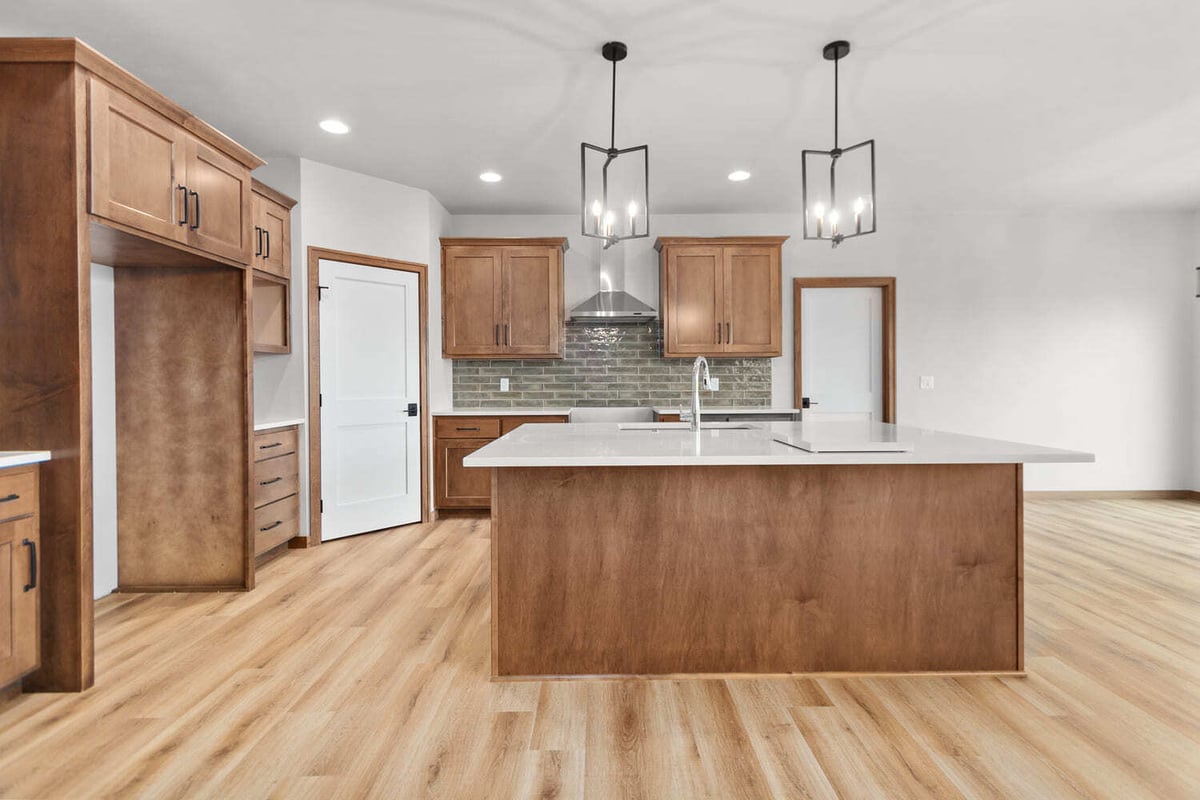 Bright Fox Cities kitchen showcasing large island, tile backsplash, and modern pendant lighting