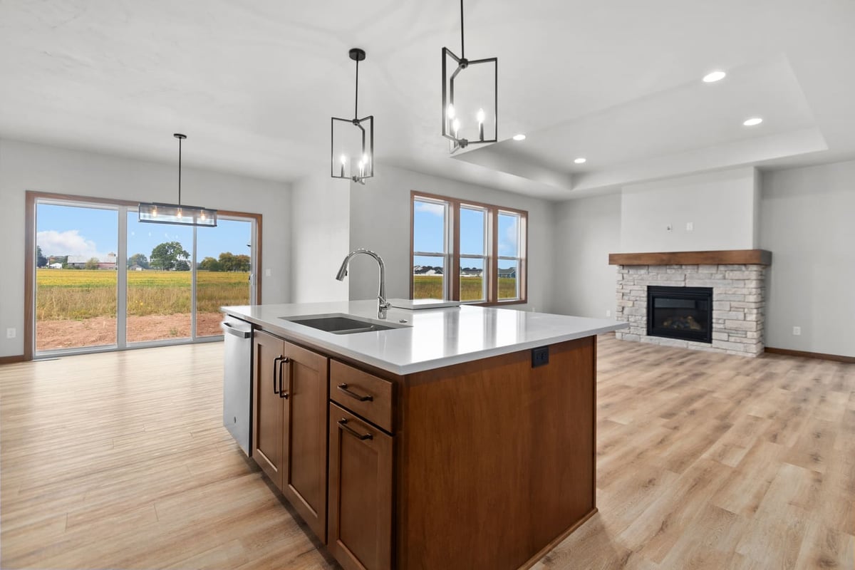 Fox Cities kitchen island with quartz countertop, modern pendant lighting, and open living area with fireplace