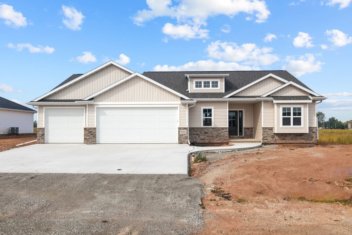 Front exterior of a single-story home with attached garage, siding, and stone accents located in the Fox Cities