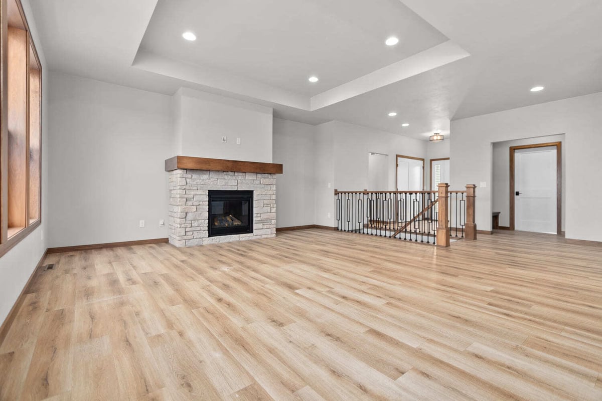 Spacious Fox Cities open-concept great room with kitchen, railing detail, wood floors, and recessed lighting