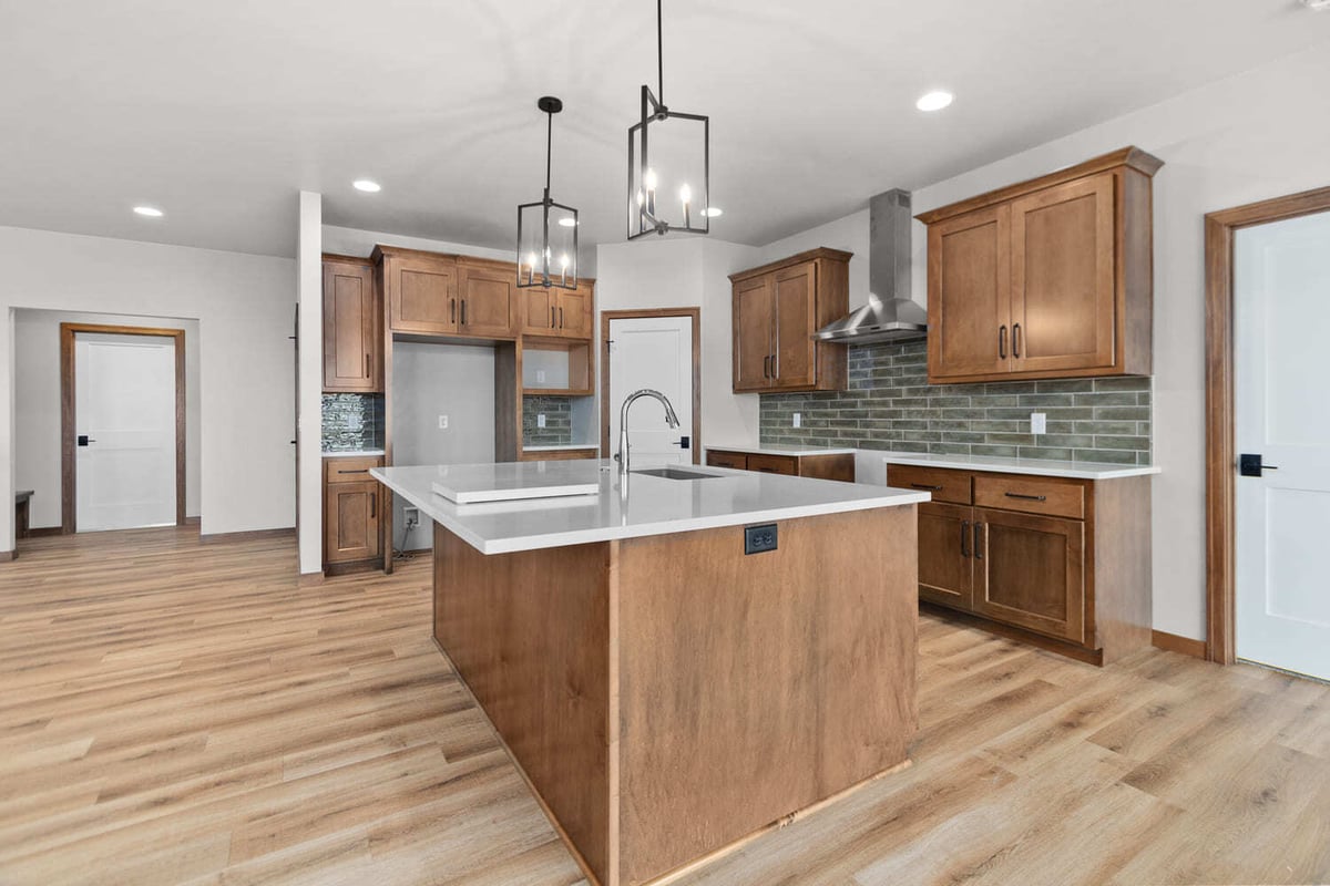 Spacious kitchen with oversized island, stainless appliances, and wood cabinetry in a Fox Cities residence