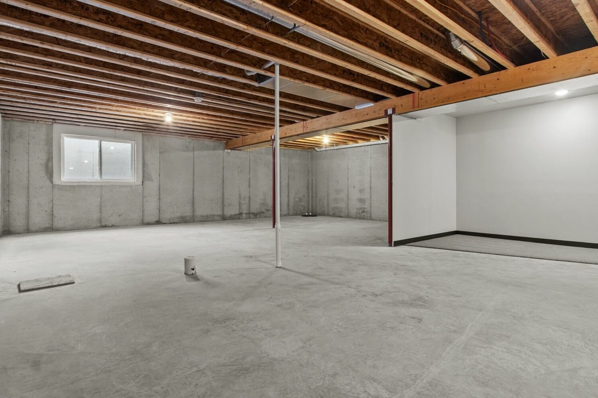 Basement with concrete floors and open framing in custom home by Midwest Design Homes in Lawrence, WI