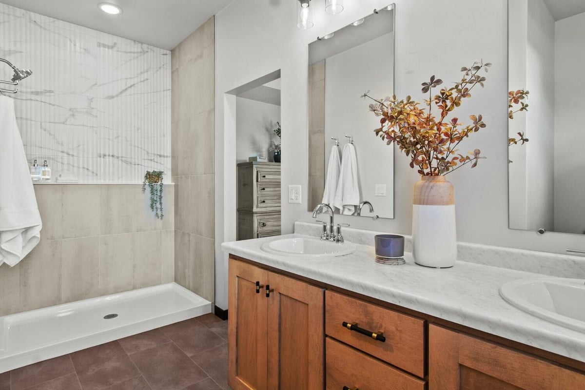 Bathroom with dual sinks and wood cabinetry by Midwest Design Homes in Lawrence, WI