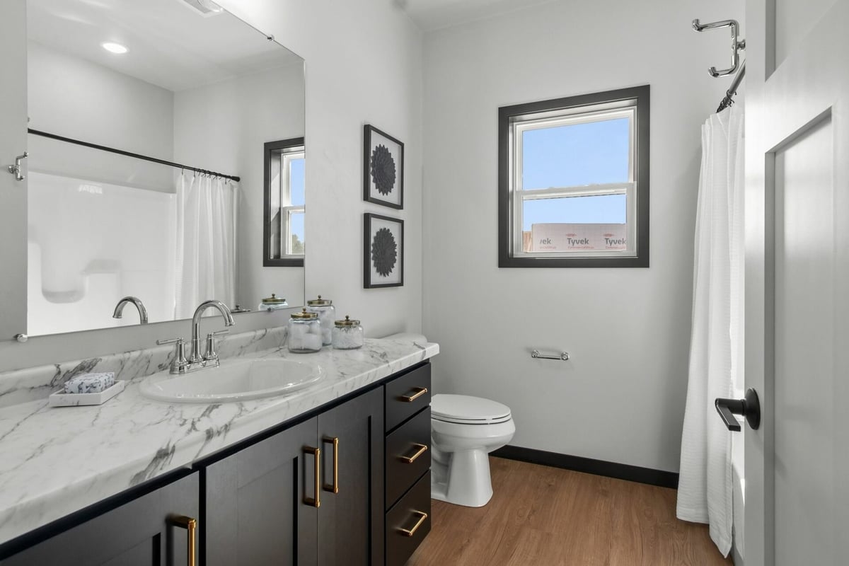Bathroom with marble countertop and double sinks in custom home by Midwest Design Homes in Ellington, WI