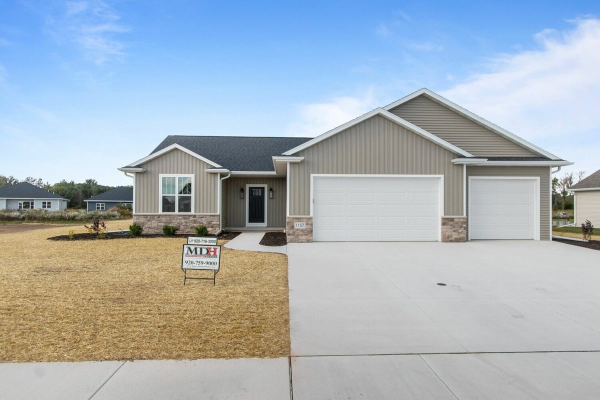 Front elevation of a custom ranch-style home with three-car garage by Midwest Design Homes in Kaukauna, WI