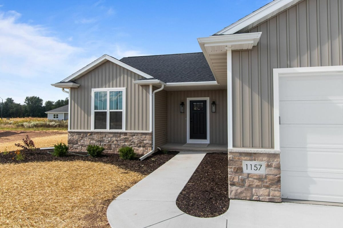 Front entry of a custom-built home with stone and siding exterior by Midwest Design Homes in Lawrence, WI