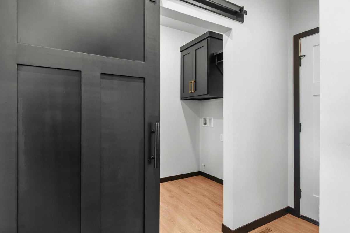 Laundry room with barn-style sliding door in custom home by Midwest Design Homes in Ledgeview, WI