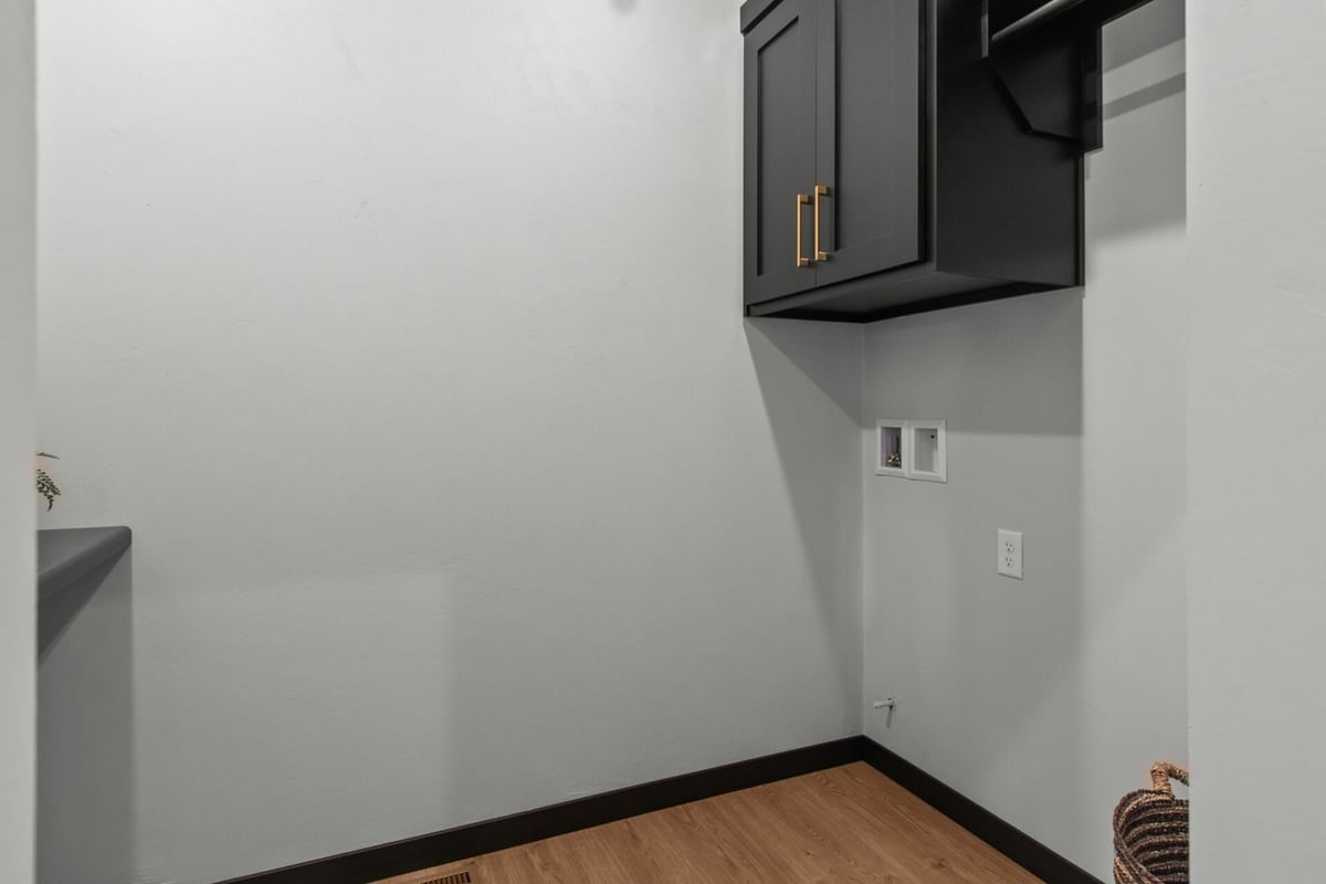 Laundry room with black cabinetry in custom home by Midwest Design Homes in Fox Cities, WI