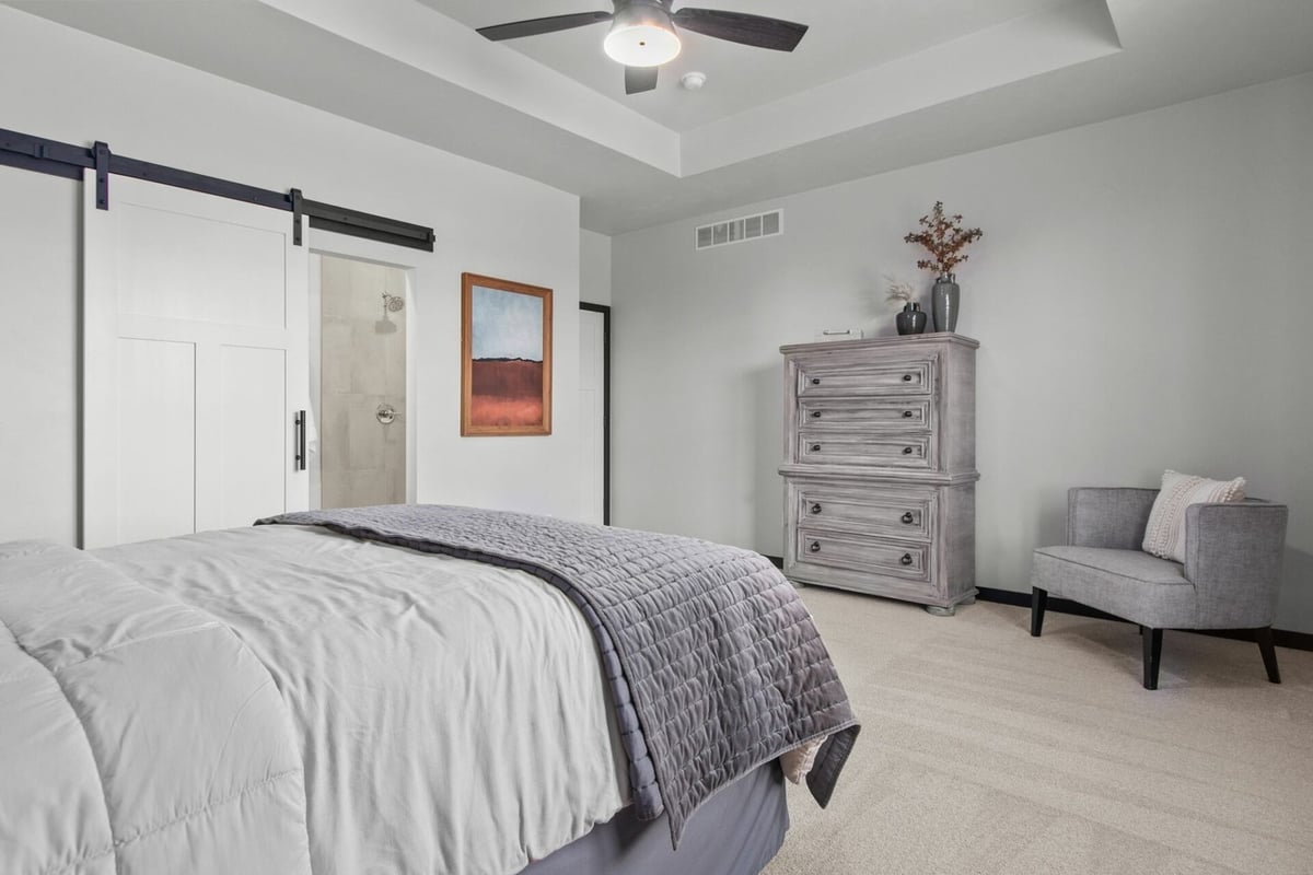 Master bedroom interior with tray ceiling and neutral design in custom home by Midwest Design Homes in Kaukauna, WI
