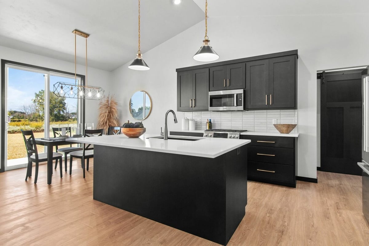 Modern kitchen with white island and black cabinetry in custom home by Midwest Design Homes in Appleton, WI
