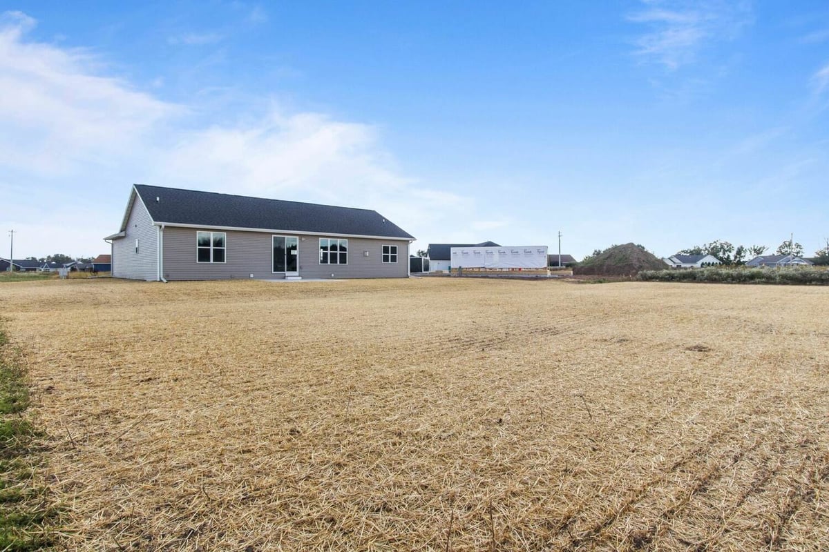 Rear view of custom-built home with fresh landscaping by Midwest Design Homes in Lawrence, WI