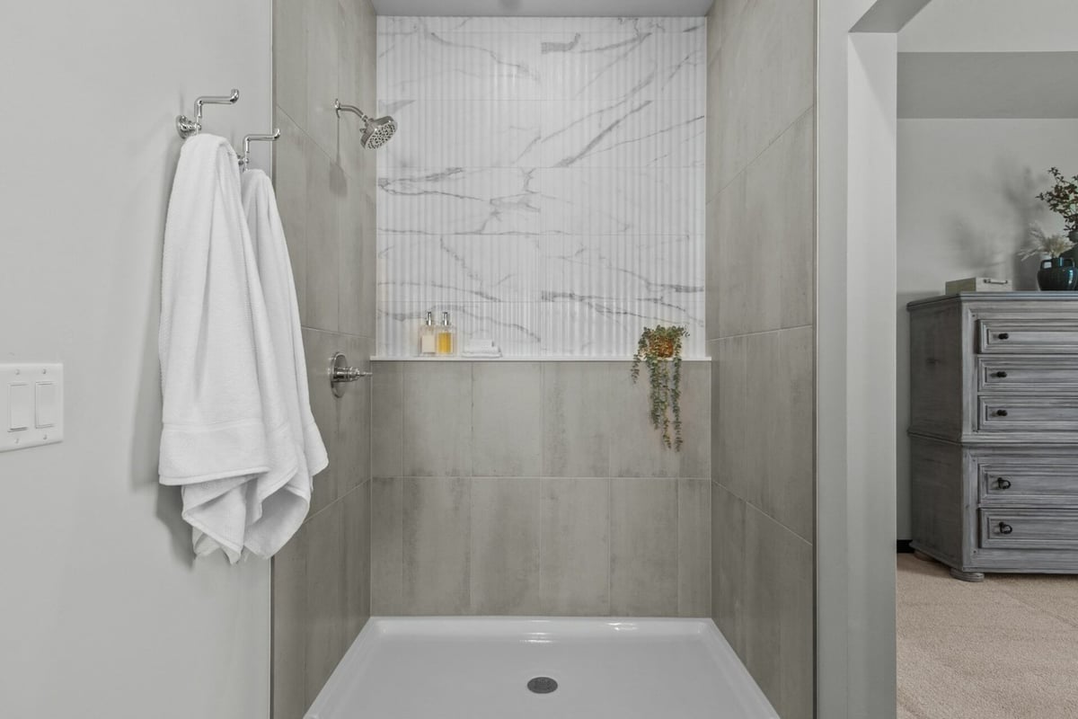 Walk-in shower with marble tile accents by Midwest Design Homes in Green Bay, WI