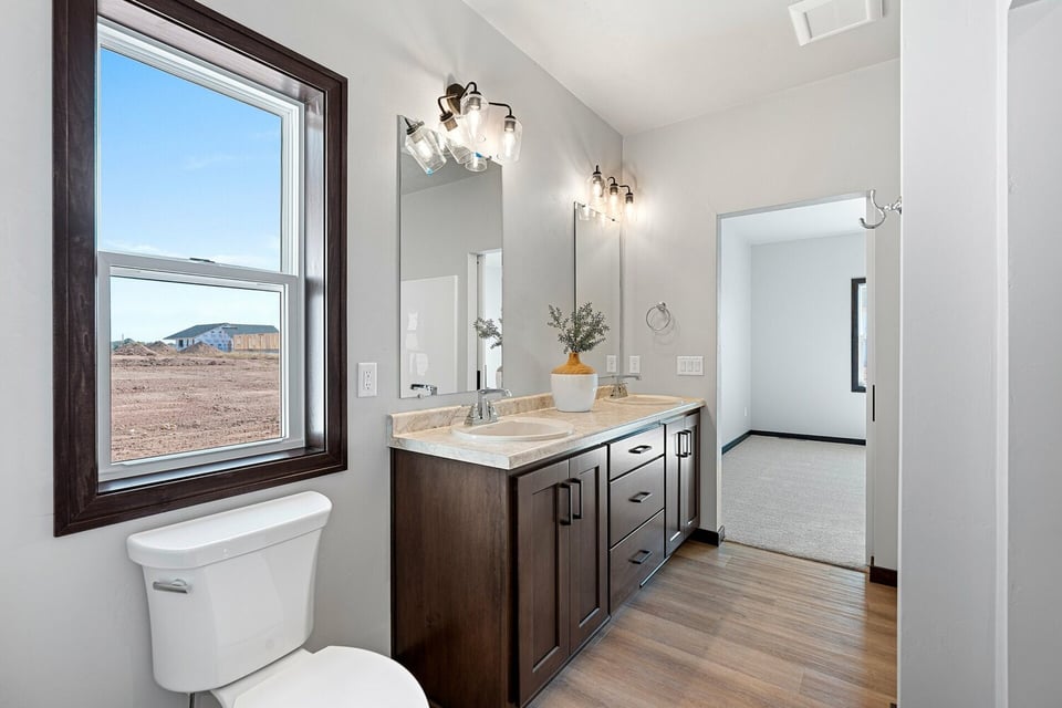 Bright bathroom design with sleek cabinetry in a Midwest Design Homes custom home in Ellington, WI.