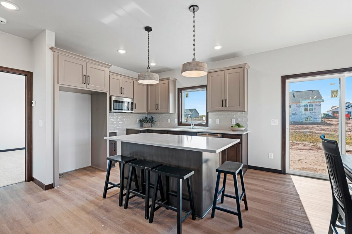 Kitchen interior featuring quartz countertops and natural light in a custom home by Midwest Design Homes.