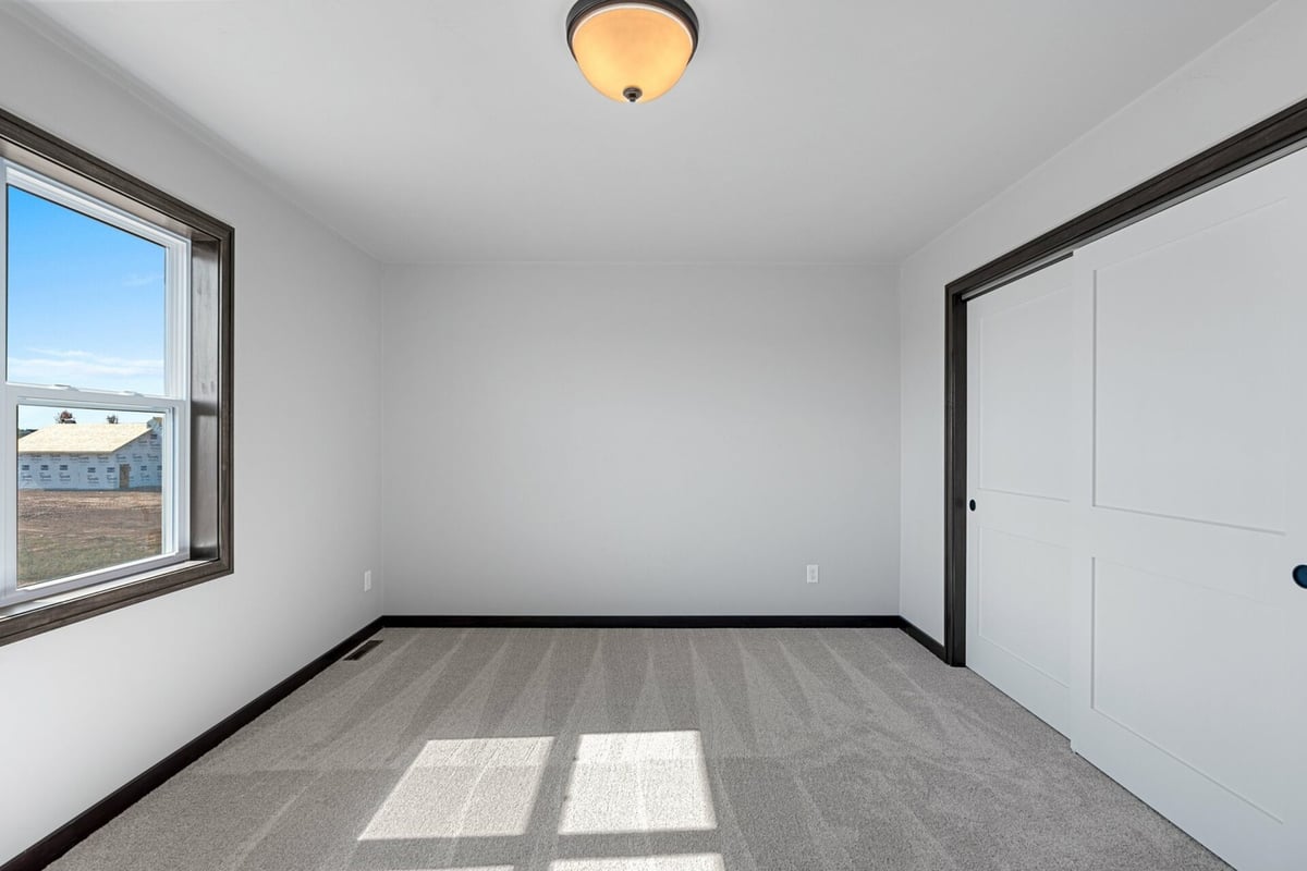 Minimalist bedroom design with natural light and closet space by Midwest Design Homes in Green Bay, WI.