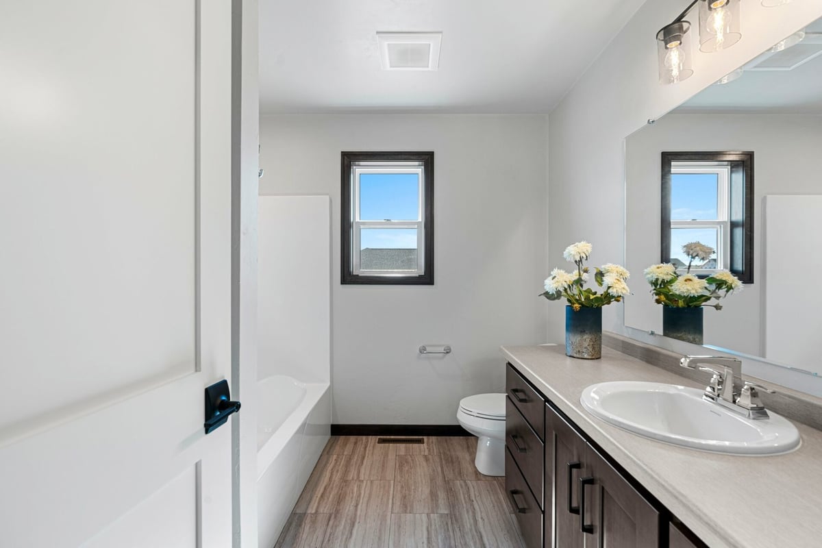 Neutral-toned bathroom with single vanity and floral decor by Midwest Design Homes in Appleton, WI.