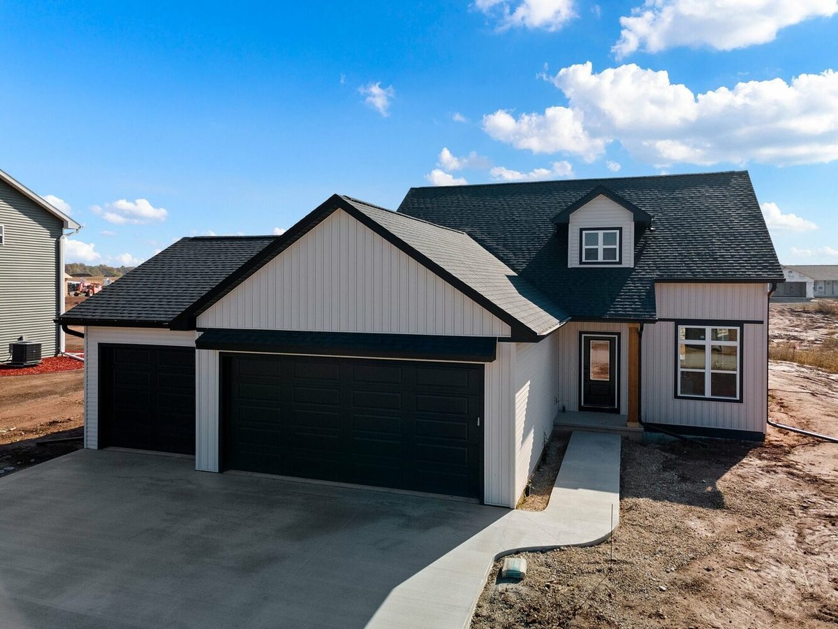 Newly constructed black and white custom home with three-car garage in the Fox Cities, WI area by Midwest Design Homes.