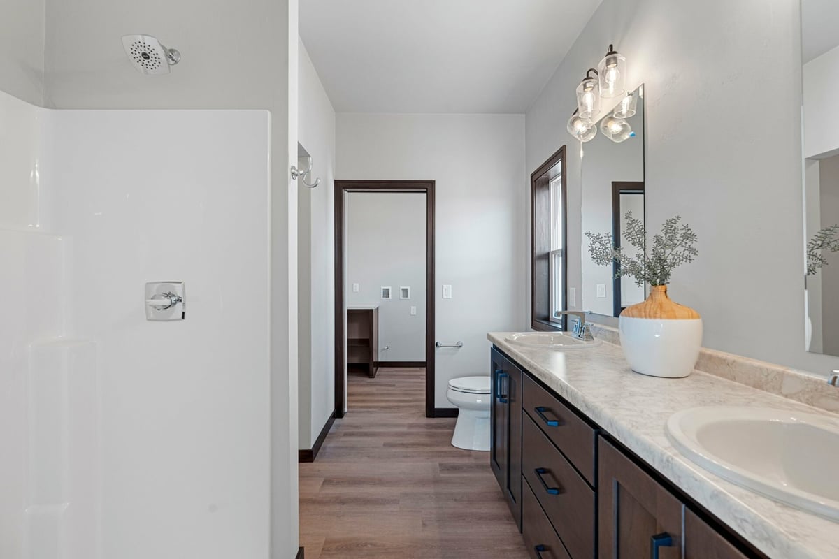 Walk-in shower and double vanity layout in a custom home bathroom by Midwest Design Homes in Fremont, WI.
