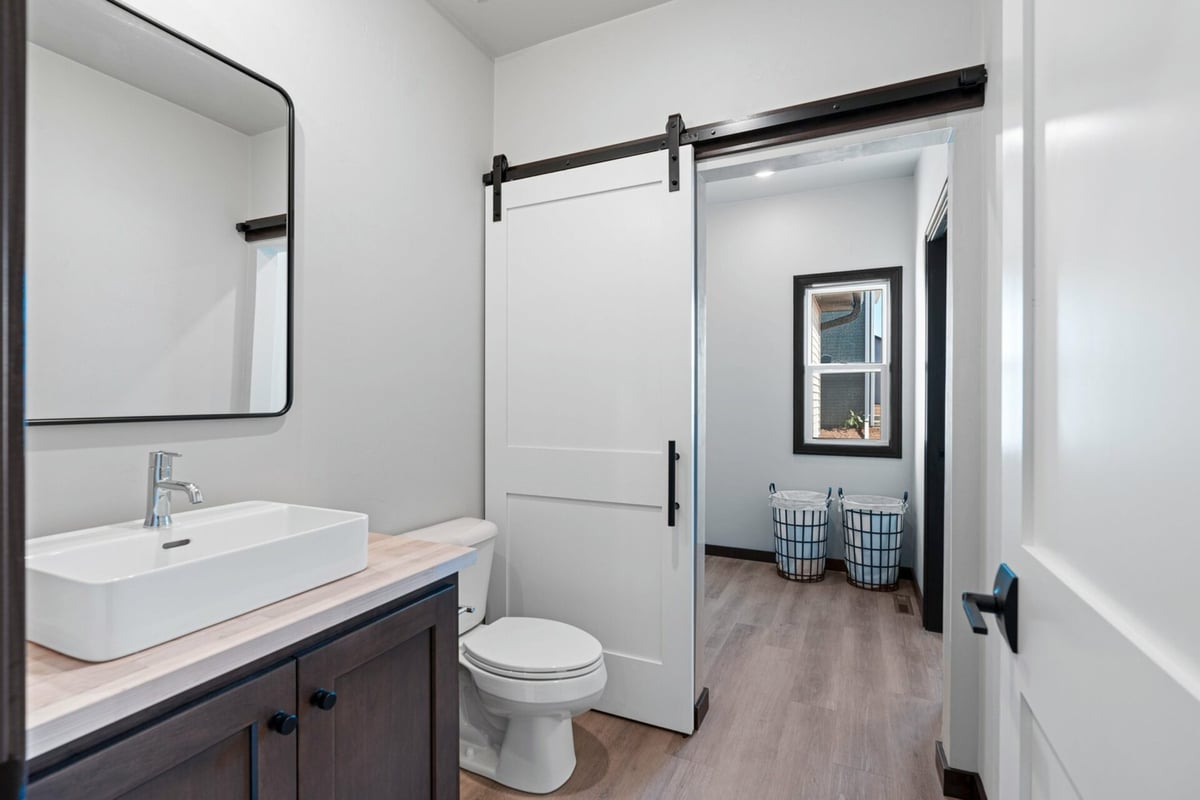 White sliding barn door and modern bathroom design in a Midwest Design Homes custom home in De Pere, WI.