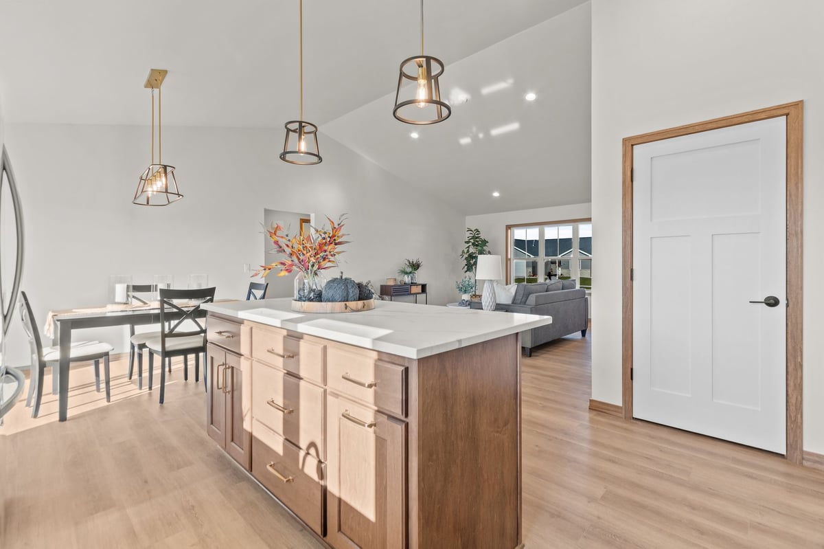 Bright open kitchen with large island, pendant lighting, and adjacent dining and living areas, located in the Fox Cities
