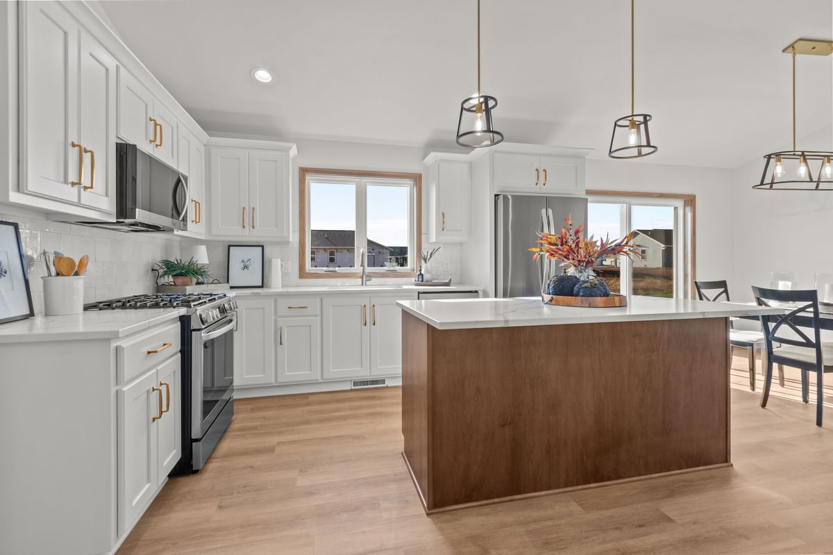 Bright white kitchen with large island, stainless appliances, and pendant lighting, located in the Fox Cities