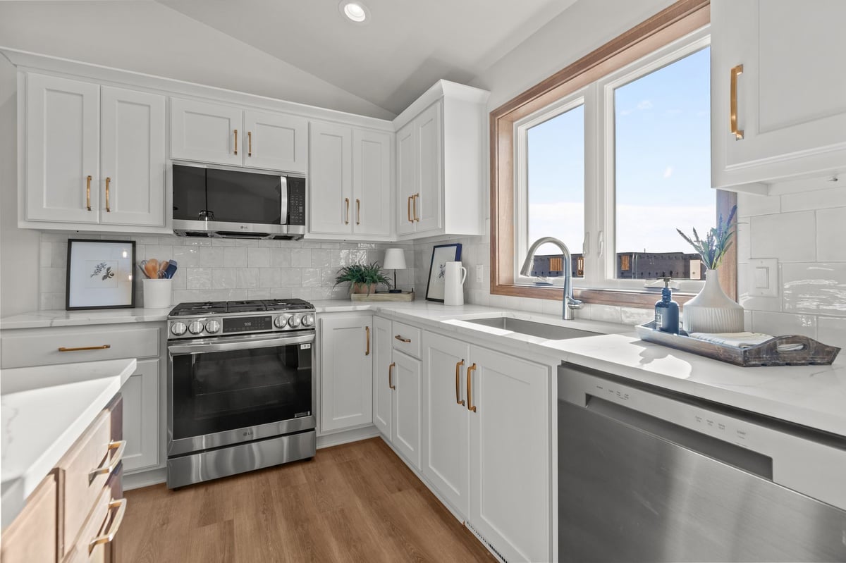 Bright white kitchen with stainless range, dishwasher, and window over sink, located in the Fox Cities